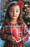 Ritratto di uno sveglio, bambina del primo piano che tiene una candela immagine stock Ritratto di uno sveglio, bambina del primo piano che tiene una candela immagine stock