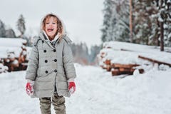 Ritratto felice divertente della ragazza del bambino sulla passeggiata nella foresta nevosa di inverno con sradicamento di alberi fotografia stock Ritratto felice divertente della ragazza del bambino sulla passeggiata nella foresta nevosa di inverno con sradicamento di alberi fotografia stock
