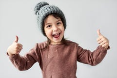 Ritratto orizzontale del primo piano della bambina sorridente felice nel cappello grigio caldo di inverno, maglione d'uso e di mo immagine stock Ritratto orizzontale del primo piano della bambina sorridente felice nel cappello grigio caldo di inverno, maglione d'uso e di mo immagine stock
