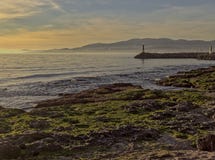 Rivage de Palma avec de la mousse sur des roches, des montagnes, des balises de lumière et le beau ciel, Majorque, Espagne photographie stock libre de droits Rivage de Palma avec de la mousse sur des roches, des montagnes, des balises de lumière et le beau ciel, Majorque, Espagne photographie stock libre de droits