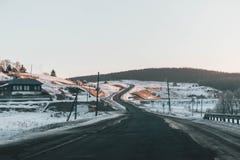 Road disappears behind the beautiful juniper tree in the sunny and frosty winter landscape royalty free stock photography Road disappears behind the beautiful juniper tree in the sunny and frosty winter landscape royalty free stock photography