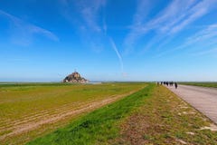 Road to amazing Mont Saint Michel abbey. Landscape photo during sunrise. Normandy, France. Road to amazing Mont Saint Michel abbey. Tourists are going to the Stock Photos Road to amazing Mont Saint Michel abbey. Landscape photo during sunrise. Normandy, France. Road to amazing Mont Saint Michel abbey. Tourists are going to the Stock Photos