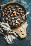 Roasted chestnuts in cast iron pan over dark blue background royalty free stock photos Roasted chestnuts in cast iron pan over dark blue background royalty free stock photos