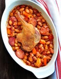 Roasted duck leg with Cassoulet beans, onions, bacon, carrots with fried pork sausage stock photo Roasted duck leg with Cassoulet beans, onions, bacon, carrots with fried pork sausage stock photo