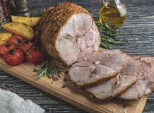 Roasted pork roulade sliced, roll with potato and tomato on cutting board stock photos Roasted pork roulade sliced, roll with potato and tomato on cutting board stock photos
