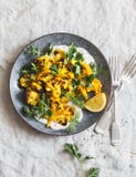 Roasted turmeric cauliflower with greek yogurt dressing. Delicious healthy food on a grey background stock photography Roasted turmeric cauliflower with greek yogurt dressing. Delicious healthy food on a grey background stock photography
