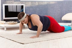 Robi push-ups w domu z nadwagą kobieta fotografia stock Robi push-ups w domu z nadwagą kobieta fotografia stock