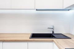 Robinet d'eau moderne de chrome de concepteur au-dessus de nouvel évier de cuisine noir L'emplacement de travail de la surface de Photographie stock Robinet d'eau moderne de chrome de concepteur au-dessus de nouvel évier de cuisine noir L'emplacement de travail de la surface de Photographie stock