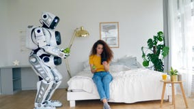 A robot is bringing apples to a young woman stock footage A robot is bringing apples to a young woman stock footage