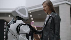 The robot looks at the girl. Artificial intelligence. Modern robotic technologies. The robot looks at the girl with