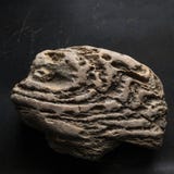 Roccia stagionata su fondo graffiato scuro Manufatto leggendario del concetto di simbolo di potere, di coraggio e di guarigione fotografia stock Roccia stagionata su fondo graffiato scuro Manufatto leggendario del concetto di simbolo di potere, di coraggio e di guarigione fotografia stock