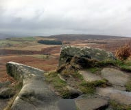 Roches us?es et une vue sur la voie amenant au visage de roche de bord de Stanage image stock Roches us?es et une vue sur la voie amenant au visage de roche de bord de Stanage image stock