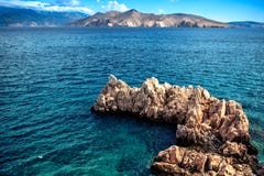 Rocks On Cliffs And Waves In The Ocean, Seen From A Beach. Calm Water, Clear Sky And Waves On A Sunny Summer Day Royalty Free Stock Image Rocks On Cliffs And Waves In The Ocean, Seen From A Beach. Calm Water, Clear Sky And Waves On A Sunny Summer Day Royalty Free Stock Image