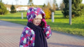 6 roczniaka dziewczyna opowiada na telefonie w parku w kapeluszu i kurtce zbiory 6 roczniaka dziewczyna opowiada na telefonie w parku w kapeluszu i kurtce zbiory