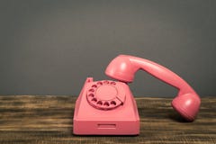 Rocznik menchie telefonują na drewnianym stole z kolor ściany tłem zdjęcie stock Rocznik menchie telefonują na drewnianym stole z kolor ściany tłem zdjęcie stock