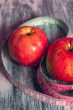 Rode appel twee met het meten van band op roze achtergrond Gezond dieetconcept Stock Foto Rode appel twee met het meten van band op roze achtergrond Gezond dieetconcept Stock Foto