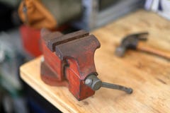 Rode bankschroef op het werkbank met hamer stock foto Rode bankschroef op het werkbank met hamer stock foto