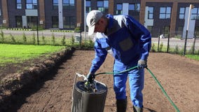 Rodillo profesional del suelo del relleno del paisajista con agua de la manguera Tiro est?tico almacen de metraje de vídeo Rodillo profesional del suelo del relleno del paisajista con agua de la manguera Tiro est?tico almacen de metraje de vídeo