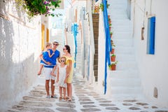 Rodzinny wakacje w małym europejskim mieście Rodzice i dzieciaki przy ulicą grecka tradycyjna wioska na Mykonos wyspie zdjęcia stock Rodzinny wakacje w małym europejskim mieście Rodzice i dzieciaki przy ulicą grecka tradycyjna wioska na Mykonos wyspie zdjęcia stock