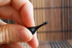 Roi de plastique de noir d'échecs, dans la main du ` s de l'homme, fond en bois Image stock Roi de plastique de noir d'échecs, dans la main du ` s de l'homme, fond en bois Image stock
