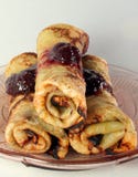 Rolled Pancakes With Strawberry Jam On A Glass Plate Stock Photo