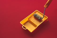 Home Repair Creativity Concept. Roller For Paint And Painting Capacity On Red Background Surface