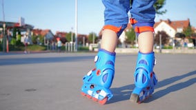 Roller skating, sports kid ride along asphalt road outdoors on an unfocused background stock video Roller skating, sports kid ride along asphalt road outdoors on an unfocused background stock video