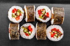 Rollo de sushi - Maki Sushi con pimienta, el pepino, el tomate y la col en la placa negra imágenes de archivo libres de regalías Rollo de sushi - Maki Sushi con pimienta, el pepino, el tomate y la col en la placa negra imágenes de archivo libres de regalías