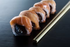 Rollos de sushi frescos deliciosos con los salmones y el queso cremoso en la placa negra Comida japonesa tradicional, concepto sa foto de archivo libre de regalías Rollos de sushi frescos deliciosos con los salmones y el queso cremoso en la placa negra Comida japonesa tradicional, concepto sa foto de archivo libre de regalías