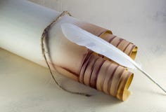 Rolo de papel velho, amarrado com uma corda, e uma pena branca fotografia de stock royalty free Rolo de papel velho, amarrado com uma corda, e uma pena branca fotografia de stock royalty free