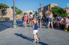 ROM, ITALIEN - JULI 2017: Ein kleines reizend touristisches Mädchen läuft auf einen Roller entlang den Straßen von altem Rom nahe lizenzfreie stockfotografie ROM, ITALIEN - JULI 2017: Ein kleines reizend touristisches Mädchen läuft auf einen Roller entlang den Straßen von altem Rom nahe lizenzfreie stockfotografie