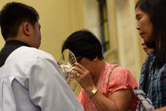 Roman Catholic Women ges sällsynt möjlighet av att kyssa den heliga monstrans under en stadfestlighet royaltyfri fotografi Roman Catholic Women ges sällsynt möjlighet av att kyssa den heliga monstrans under en stadfestlighet royaltyfri fotografi