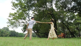 Romantic asian couple dancing in garden with happy emotion. stock footage Romantic asian couple dancing in garden with happy emotion. stock footage