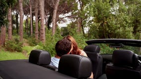 Romantic couple kissing in a convertible car