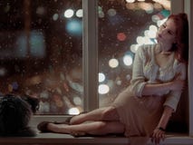 Romantic woman and a cat sitting on a window royalty free stock images Romantic woman and a cat sitting on a window royalty free stock images