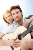 Romantische Paare, die auf dem Strand spielt Gitarre sitzen stockfotos Romantische Paare, die auf dem Strand spielt Gitarre sitzen stockfotos