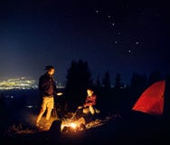 Romantische Paare nähern sich Lagerfeuer nachts sternenklares stockbilder Romantische Paare nähern sich Lagerfeuer nachts sternenklares stockbilder