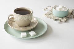Romantisk frukostplats med koppen och tefatet, te, mintkaramellgräsplanbunke med sockerkuber royaltyfria foton Romantisk frukostplats med koppen och tefatet, te, mintkaramellgräsplanbunke med sockerkuber royaltyfria foton
