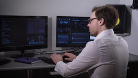 The room with computers. The man using the special software tries to find important information. The person a white