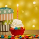 Room cupcake met een kaars op een feestelijke achtergrond met giften wordt verfraaid die Het concept van de verjaardag stock fotografie Room cupcake met een kaars op een feestelijke achtergrond met giften wordt verfraaid die Het concept van de verjaardag stock fotografie