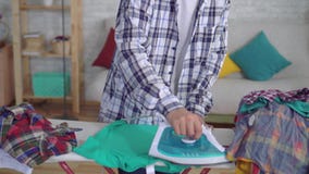 Ropa que plancha del hombre asiático joven en cierre del tablero que plancha para arriba metrajes Ropa que plancha del hombre asiático joven en cierre del tablero que plancha para arriba metrajes