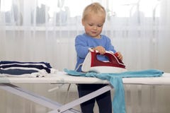 Ropa que plancha sonriente feliz del muchacho Niño que ayuda con quehacer doméstico Autonomía encouraging en niños fotos de archivo Ropa que plancha sonriente feliz del muchacho Niño que ayuda con quehacer doméstico Autonomía encouraging en niños fotos de archivo