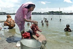 Ropa que se lava de la mujer de Bangladesh en el lago imagen de archivo Ropa que se lava de la mujer de Bangladesh en el lago imagen de archivo