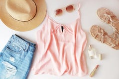 Ropa y accesorios de la mujer: top rosado, falda de los vaqueros, perfume, sandalias, gafas de sol, sombrero, lápiz labial en el fotos de archivo Ropa y accesorios de la mujer: top rosado, falda de los vaqueros, perfume, sandalias, gafas de sol, sombrero, lápiz labial en el fotos de archivo