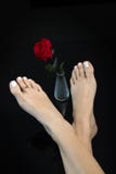 Rosa cruzada y hermosa de los pies bonitos del rojo en el florero de cristal en el centro, pie de la mujer en fondo negro abstrac fotos de archivo Rosa cruzada y hermosa de los pies bonitos del rojo en el florero de cristal en el centro, pie de la mujer en fondo negro abstrac fotos de archivo