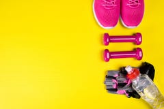 Rosa gymnastikskor och tillbehör för kondition och en flaska av vatten, på en gul bakgrund, med ett ställe för att skriva fotografering för bildbyråer Rosa gymnastikskor och tillbehör för kondition och en flaska av vatten, på en gul bakgrund, med ett ställe för att skriva fotografering för bildbyråer