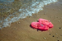 Rosa kvinnors GELÉSANDALER på en havskust DAMLÄGENHETEN GÖRA GELÉ AV SOMMARSTRANDSKOR royaltyfri foto Rosa kvinnors GELÉSANDALER på en havskust DAMLÄGENHETEN GÖRA GELÉ AV SOMMARSTRANDSKOR royaltyfri foto