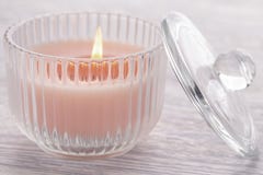 Rosa stearinljusbränning i en exponeringsglasdryckeskärl på en gammal vit trätabell arkivfoto Rosa stearinljusbränning i en exponeringsglasdryckeskärl på en gammal vit trätabell arkivfoto