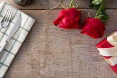 Rosas vermelhas com a caixa de presente na mesa de jantar Dia do Valentim imagem de stock Rosas vermelhas com a caixa de presente na mesa de jantar Dia do Valentim imagem de stock