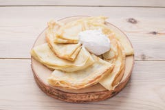 Rosjanów ciency bliny na drewnianym stojaku robić naturalny drewno z kwaśną śmietanką Maslenitsa jest Maslenitsa jedzenia festiwa fotografia stock Rosjanów ciency bliny na drewnianym stojaku robić naturalny drewno z kwaśną śmietanką Maslenitsa jest Maslenitsa jedzenia festiwa fotografia stock